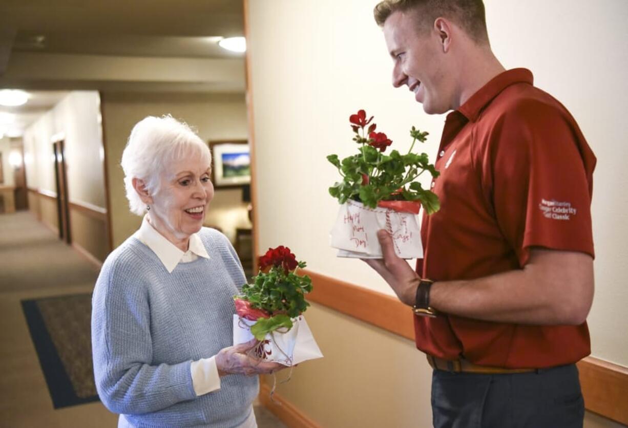 Maxine Benshoof, left, accepts a pot of flowers from Jake Bredstrand, a WSU Vancouver volunteer and Evergreen High School graduate, Tuesday at The Quarry Senior Living center in east Vancouver. Benshoof graduated from WSU in 1955 with a degree in nursing. On May 1, May Day, WSU Vancouver alumni and volunteers built and delivered flowers to WSU Golden Grads, alumni who graduated 50 or more years ago. Top: Handwritten notes accompanied small pots of flowers for Washington State University Golden Grads on Tuesday.