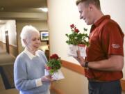 Maxine Benshoof, left, accepts a pot of flowers from Jake Bredstrand, a WSU Vancouver volunteer and Evergreen High School graduate, Tuesday at The Quarry Senior Living center in east Vancouver. Benshoof graduated from WSU in 1955 with a degree in nursing. On May 1, May Day, WSU Vancouver alumni and volunteers built and delivered flowers to WSU Golden Grads, alumni who graduated 50 or more years ago. Top: Handwritten notes accompanied small pots of flowers for Washington State University Golden Grads on Tuesday.