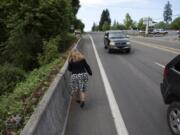 Vicki Fitzsimmons walks along what she calls a “pinch point” on Northeast Highway 99 where the sidewalk ends, forcing pedestrians to walk in a bike lane a few feet from fast-moving traffic.