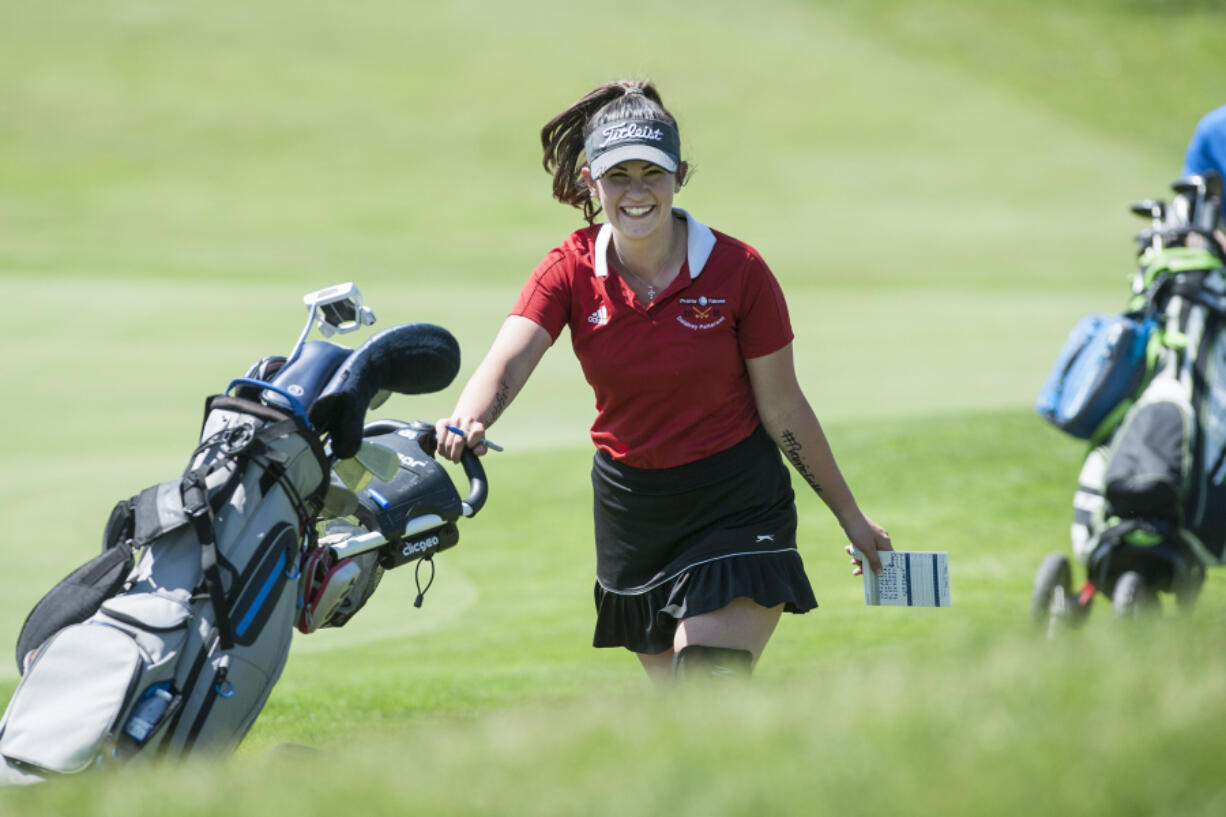 Prairie senior Delainey Patterson smiles as she moves to the next hole during the 4A and 3A district girls golf tournament at Tri-Mountain Golf Course in Ridgefield, Tuesday May 8, 2018.