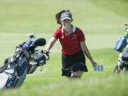 Prairie senior Delainey Patterson smiles as she moves to the next hole during the 4A and 3A district girls golf tournament at Tri-Mountain Golf Course in Ridgefield, Tuesday May 8, 2018.