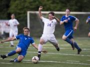 Ridgefield’s Jonathan Flury (7) slide tackles Columbia River’s Jake Connop (14).