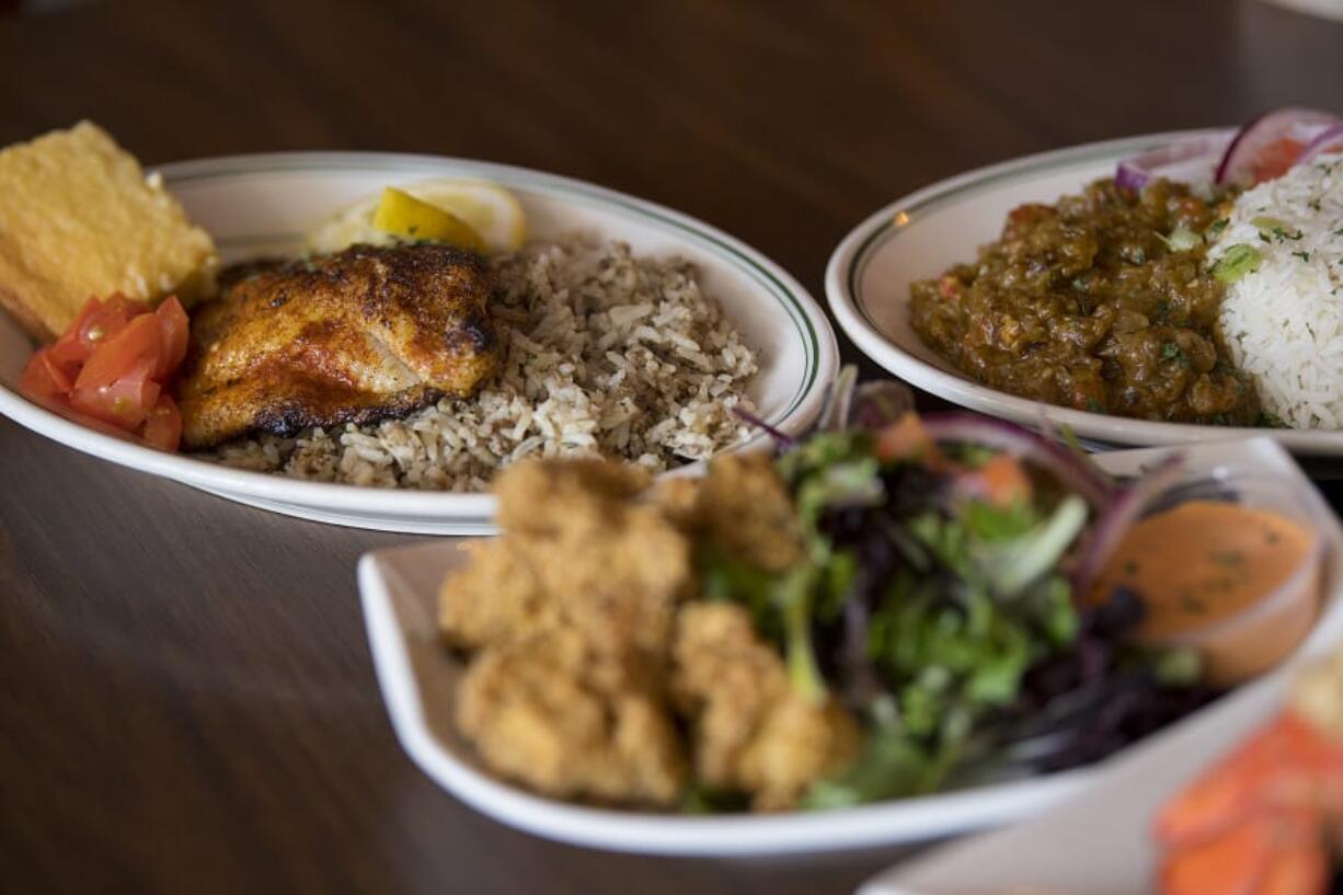 Blackened catfish, clockwise from left, is served with crawfish etoufee and alligator bites at My Brother’s Crawfish in downtown Vancouver.