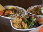 Blackened catfish, clockwise from left, is served with crawfish etoufee and alligator bites at My Brother’s Crawfish in downtown Vancouver.