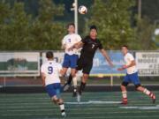 La Center's Jared Cox, 7, and Seattle Academy's Cole Hanauer, 7, jump for a header during the first round of the Class 1A state playoffs at Woodland High School on Tuesday, May 15, 2018.