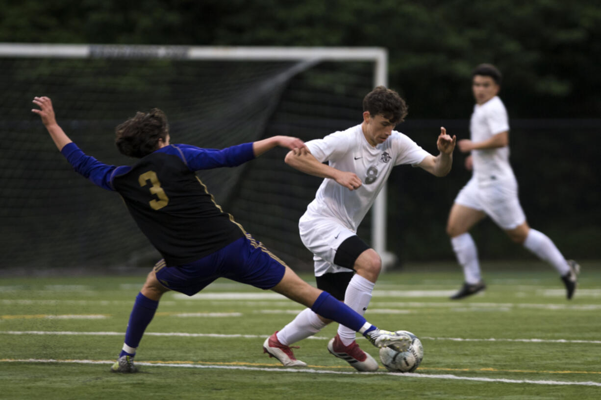 Skyview’s Stephen Kiraly (8) dribbles past Puyallup’s Jorge Saura (3) during the first round of the 4A state playoffs.