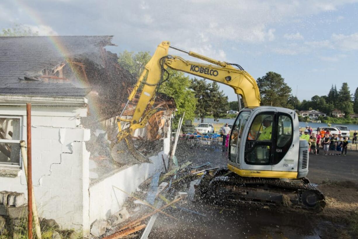 West Coast Training excavator operator Josh McClure demolishes one of the rooms at the defunct Lakeside Motel, where the Woodland Community Swimming Pool Committee plans on building a YMCA, with construction expected to start in 2020. Cowlitz Fire District No. 1 and Woodland Fire Department sprayed water on the motel to keep dust and lead paint particles down.