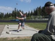 Ridgefield High School sophomore Trey Knight practices the shot put after school with his coach and grandfather John Gambill of Vancouver on Wednesday, May 23, 2018.