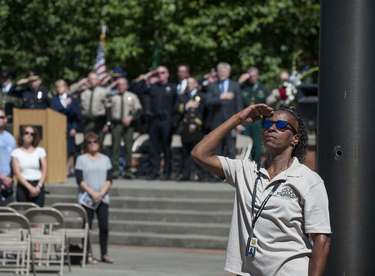 Clark County Sheriff's Office volunteer Cassandra Kendrick joins the crowd as the American flag is raised in May 2016 as part of the Law Enforcement Memorial Ceremony at the Clark County Public Service Center courtyard.