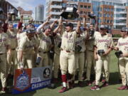 Florida State’s Cal Raleigh (35) lifts the trophy following an Atlantic Coast Conference NCAA college baseball tournament championship game against Louisville in Durham, N.C., Sunday, May 27, 2018. Florida State won 11-8.