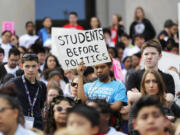 A student from Destiny Charter Middle School in Tacoma, Wash., holds a sign that reads "Students Before Politics," during a rally held by charter school students, teachers, and supporters at the Capitol in Olympia, Wash., Thursday, May 17, 2018.  Teachers unions and other groups have sued over Washington state's 2016 charter school law, which was enacted after the justices struck down the old law as unconstitutional. (AP Photo/Ted S.