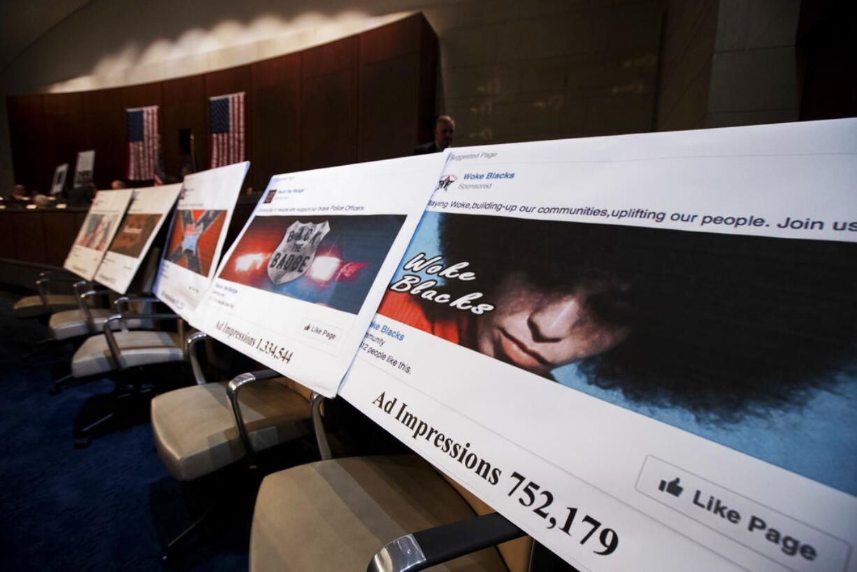 FILE- In this Nov. 1, 2017, file photo, Facebook ads linked to a Russian effort to disrupt the American political process are displayed as Google's Senior Vice President and General Counsel Kent Walker, Facebook's General Counsel Colin Stretch, and Twitter's Acting General Counsel Sean Edgett, testify during a House Intelligence Committee hearing on Capitol Hill in Washington. Facebook says it will require political advertisers in the U.S. to label “issue ads” that disclose who paid for them, part of its ongoing efforts to prevent elections-related misuse of its platform. Such ads played prominently in Russia’s efforts to interfere in the 2016 U.S. elections.