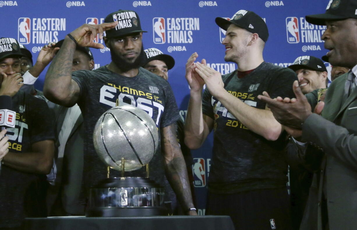 Cleveland Cavaliers forward LeBron James salutes after his team was presented the trophy for beating the Boston Celtics 87-79 in Game 7 of the NBA basketball Eastern Conference finals, Sunday, May 27, 2018, in Boston.