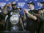 Cleveland Cavaliers forward LeBron James salutes after his team was presented the trophy for beating the Boston Celtics 87-79 in Game 7 of the NBA basketball Eastern Conference finals, Sunday, May 27, 2018, in Boston.