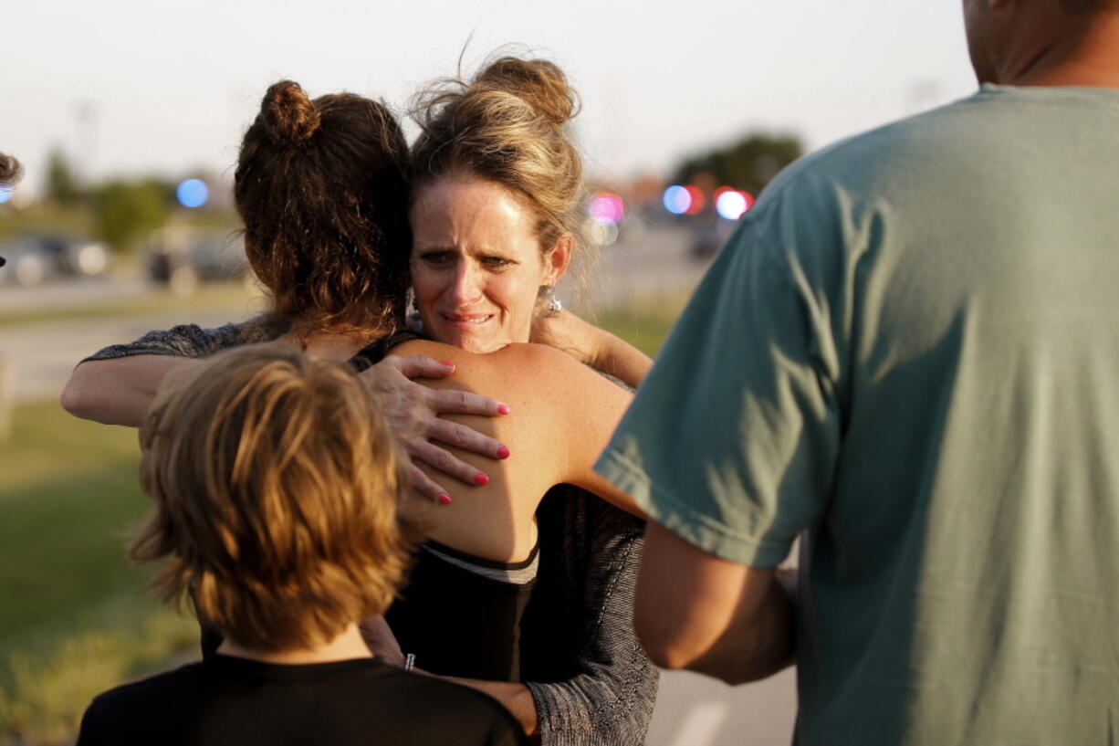 Jennifer Stong hugs Tasha Hunt outside the scene of a shooting on the east side of Lake Hefner in Oklahoma City, Thursday, May 24, 2018. Stong was inside the restaurant when the shooting occurred.