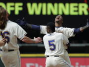 Seattle Mariners’ Jean Segura, right, celebrates with Guillermo Heredia (5) and Ben Gamel, left, after hitting a walkoff RBI-single to score Dee Gordon and give them a victory over the Detroit Tigers in the 11th inning of a baseball game Sunday, May 20, 2018, in Seattle. (AP Photo/Ted S.