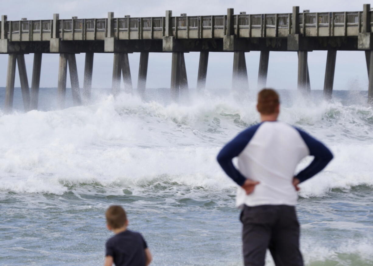 Harrison Westwood, 4, left, and his father Ben watch waves crash near the beach as a subtropical approaches on Monday in Pensacola, Fla. The storm gained the early jump on the 2018 hurricane season as it headed toward anticipated landfall sometime Monday on the northern Gulf Coast, where white sandy beaches emptied of their usual Memorial Day crowds.