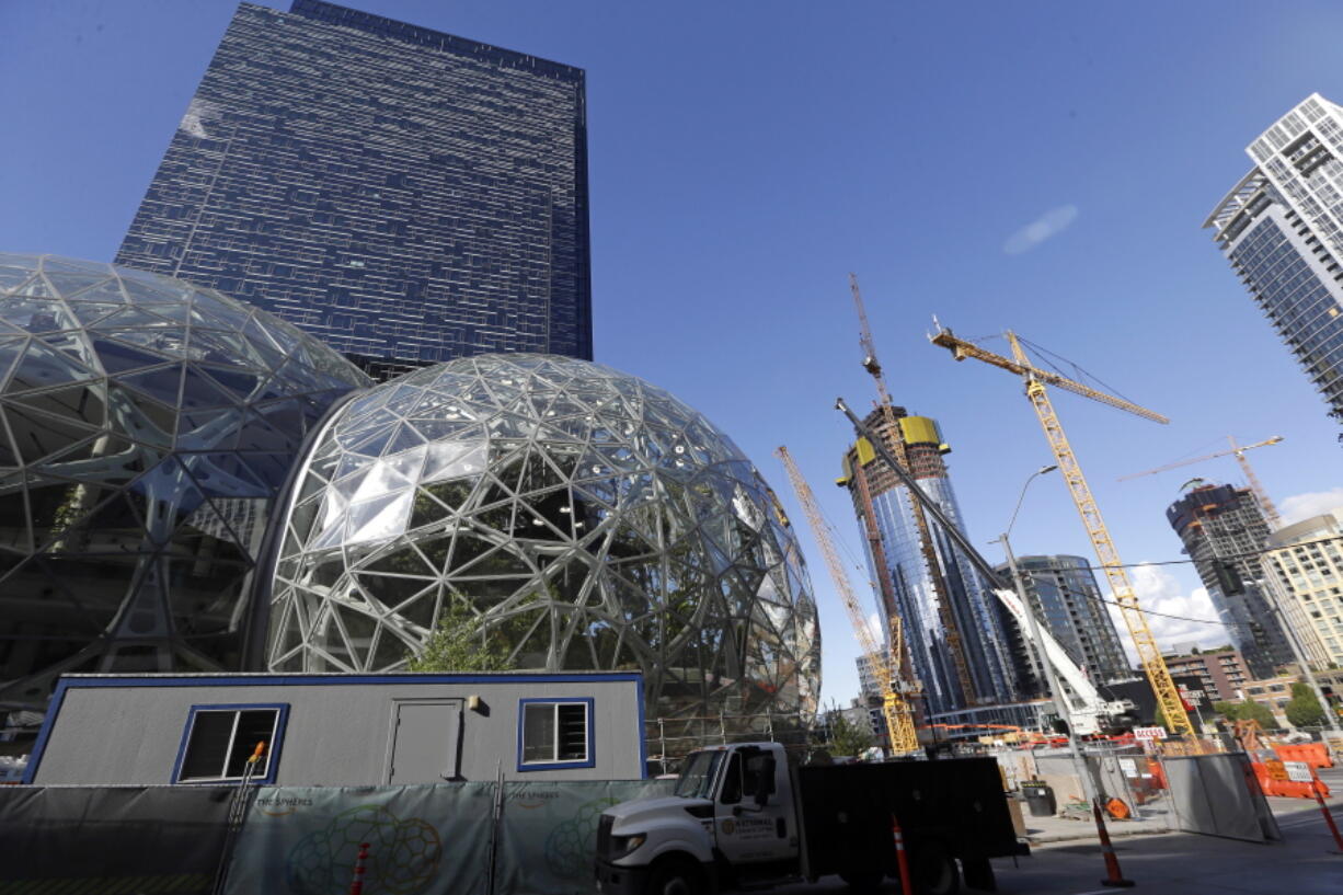 Large spheres take shape in front of an existing Amazon building Oct. 11, 2017, as new construction continues across the street in Seattle. Amazon said Wednesday it is pausing construction on a new high-rise building in Seattle while it awaits the outcome of a city proposal to tax worker hours.