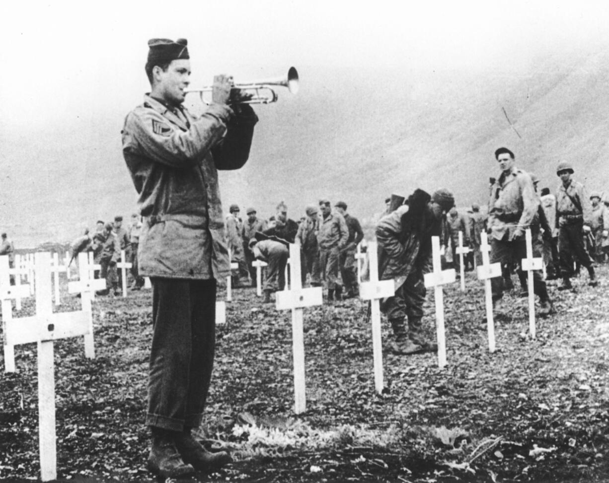 A bugler sounds taps during an August 1943 memorial service while a group of GIs visit the graves of comrades who fell in the reconquest of Attu Island, part of the Aleutian Islands of Alaska. Wednesday will mark the 75th anniversary of American forces recapturing Attu Island in Alaska’s Aleutian chain from Japanese forces. It was the only World War II battle fought on North American soil.