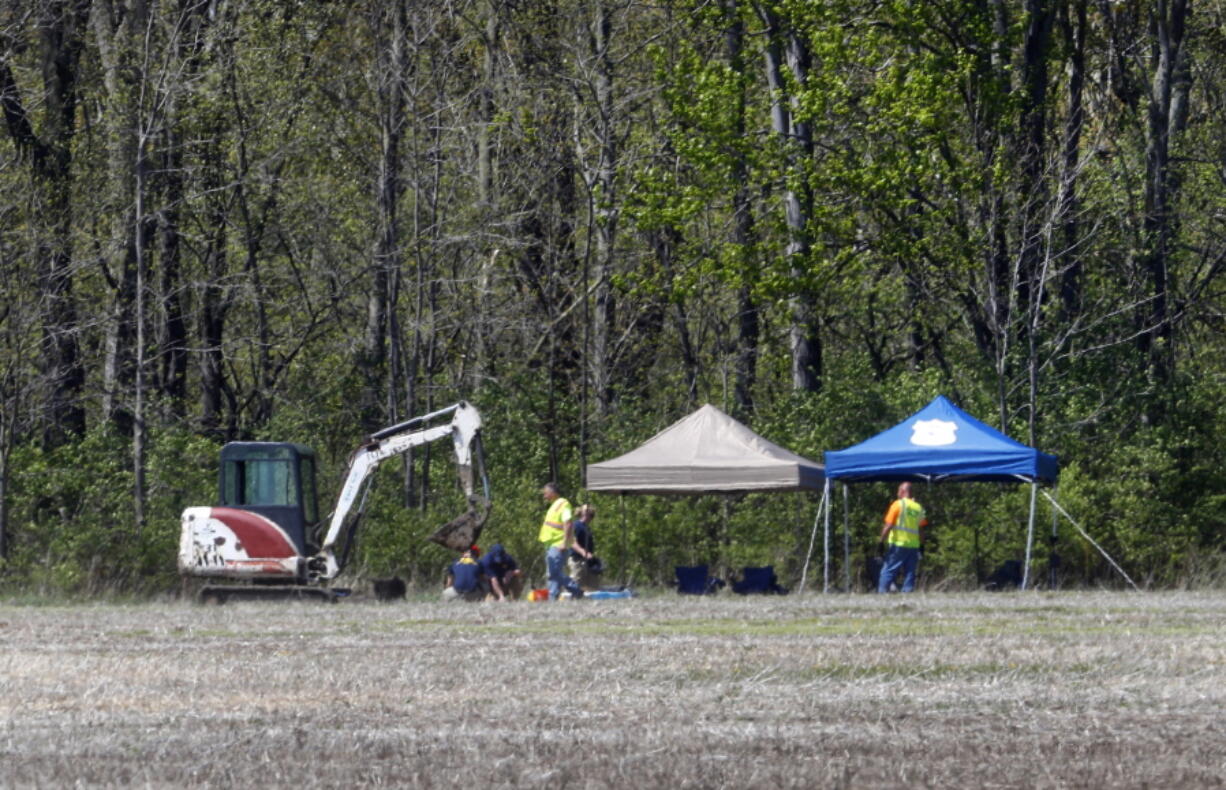 Authorities work along a rural wooded area in Macomb Township, Mich., Tuesday. Authorities excavating woods in southeastern Michigan, about 30 miles from downtown Detroit, for the remains of a 12-year-old girl last seen in 1979, also could be looking for the bodies of up to half a dozen others who have been reported missing over the years.