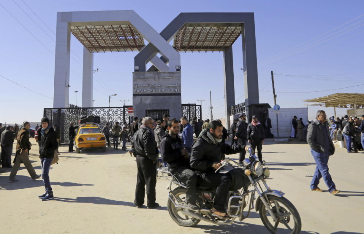 FILE - In this Tuesday, Jan. 20, 2015 file photo, Palestinians wait to cross the border to the Egyptian side at the Rafah crossing, in the southern Gaza Strip.Egypt’s President Abdel Fatah el-Sissi says he has ordered the Rafah crossing point with Gaza strip be opened for the whole Muslim holy month of Ramadan, the longest time since Hamas took over the territory in 2007.