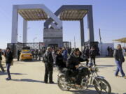 FILE - In this Tuesday, Jan. 20, 2015 file photo, Palestinians wait to cross the border to the Egyptian side at the Rafah crossing, in the southern Gaza Strip.Egypt’s President Abdel Fatah el-Sissi says he has ordered the Rafah crossing point with Gaza strip be opened for the whole Muslim holy month of Ramadan, the longest time since Hamas took over the territory in 2007.