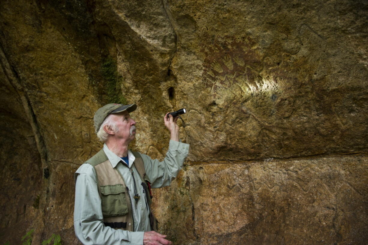 Tony Farqué, archaeologist with the Willamette National Forest, shines looks at petroglyphs created by Native Americans thousands of years ago in the Cascade Cave near Sweet Home, Ore., May 1.