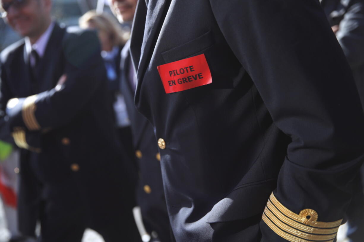 FILE - This Wednesday, April 11, 2018 file picture shows Air France pilots on strike as they gather next to the company headquarters during a demonstration in Tremblay-en-France, outside Paris, France. Sticker reads : Pilot on strike. Air France is grappling with a new strike, a sinking share price and a warning from the French government that the airline’s survival is at stake.