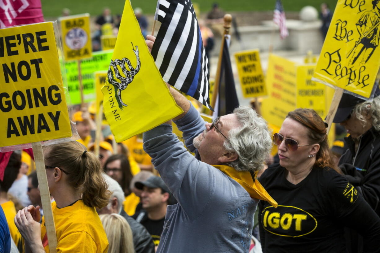 Dave Fitzgerald of Girard, Ill. waves flags April 25 while listening to speakers during the annual IGOLD (Illinois Gun Owners Lobby Day) rally at the Capitol 8 in Springfield, Ill.