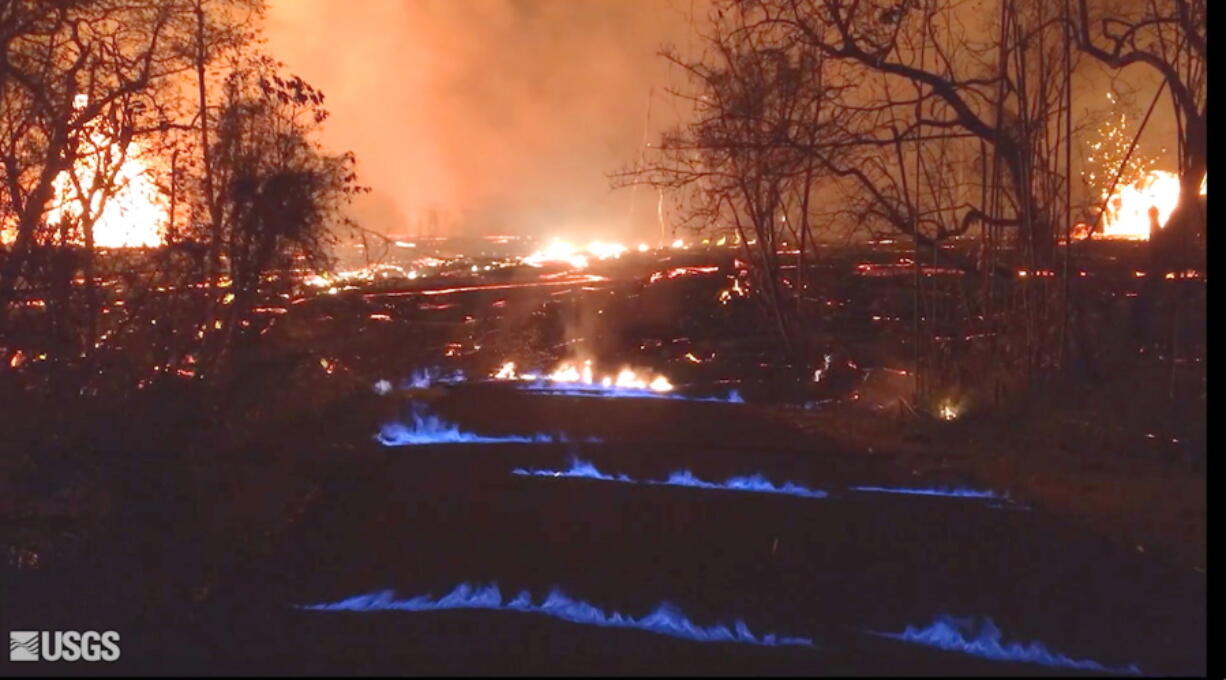 Blue flames of methane gas erupt through cracks on Kahukai Street on Wednesday in the Leilani Estates subdivision on the island of Hawaii. (U.S.