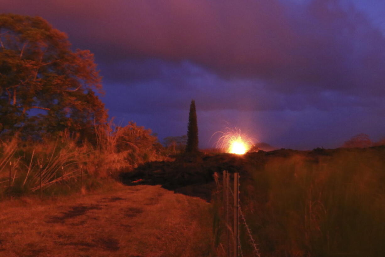 Lava explodes from a fissure on Kilauea volcano Sunday near Pahoa, Hawaii. Officials say a small eruption has occurred at the Kilauea volcano summit, producing an ash plume that reached about 7,000 feet. The County of Hawaii issued a civil defense message early Monday, May 21, 2018, about the eruption and warning that the ash plume could affect surrounding areas.