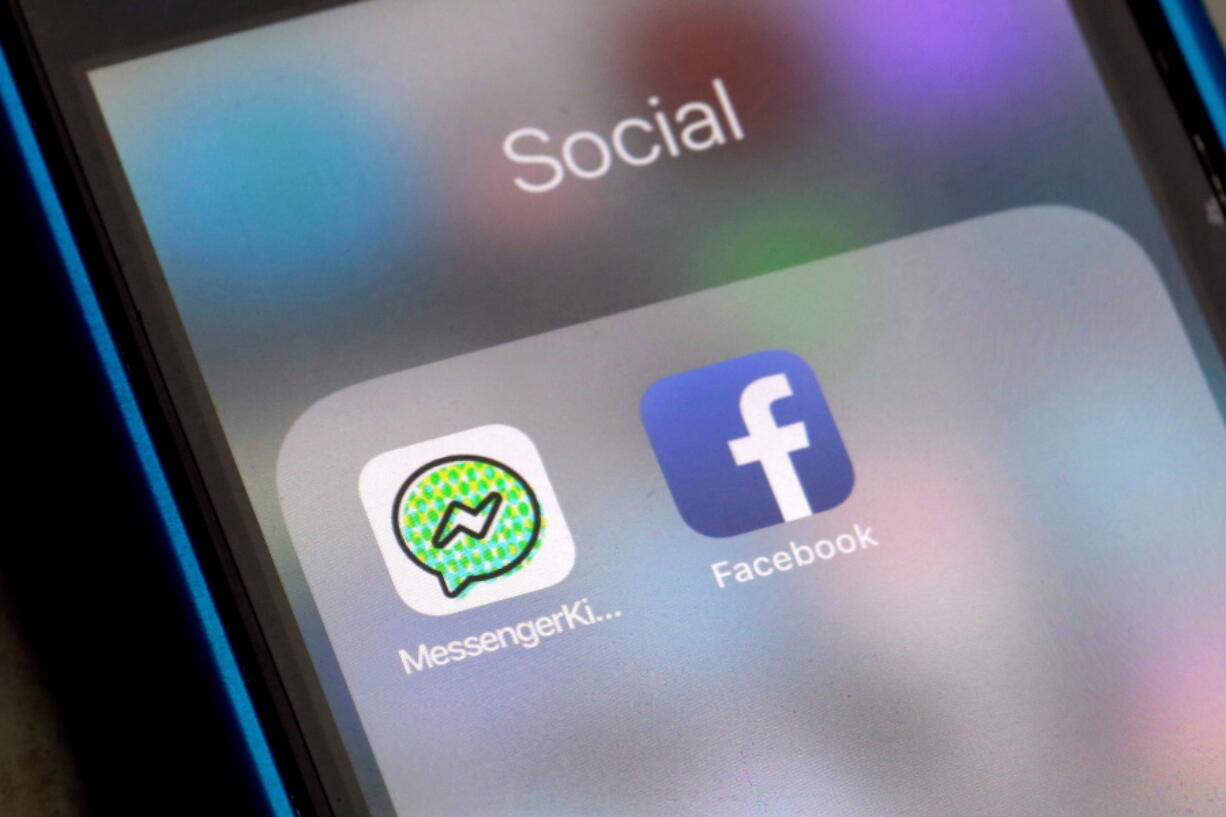 FILE- In this Feb. 16, 2018, file photo, Facebook and Facebook’s Messenger Kids app icons are displayed on an iPhone in New York. Facebook is adding a “sleep” mode to its Messenger Kids service so parents can limit how much time children spend on it.