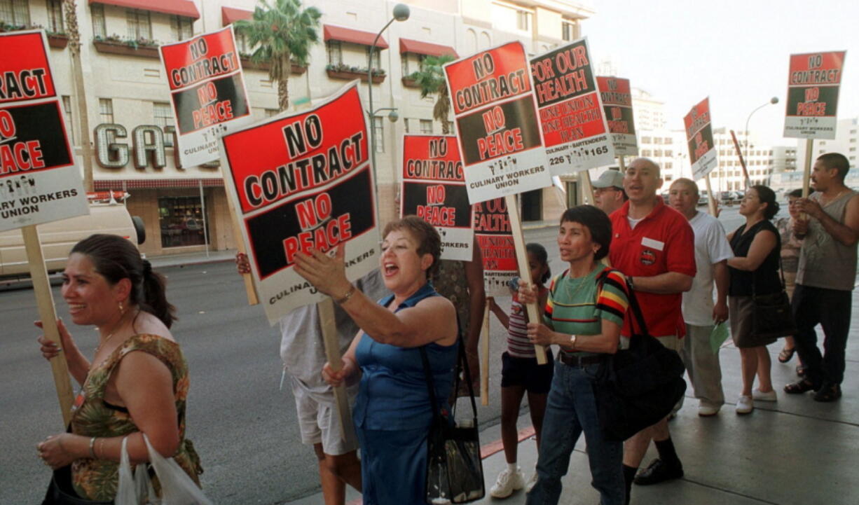 FILE - In this June 30, 2002 file photo, members of the Culinary Union Local 226 picket outside the Plaza hotel-casino in Las Vegas hours before their contract was to expire. Fifty-thousand unionized Las Vegas casino workers whose contracts will expire at the end of the month are set to vote on whether to go on strike. The Culinary Union on Wednesday, May 9, 2018, said it will hold a strike vote May 22 at a university arena.