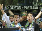 FILE - In this Aug. 27, 2017, file photo, a Seattle Sounders supporter holds up a scarf as he takes part in the traditional March to the Match before an MLS soccer match against the Portland Timbers in Seattle. The Timbers host the Sounders on Sunday in the 100th meeting between the two rivals from the Pacific Northwest. (AP Photo/Ted S.