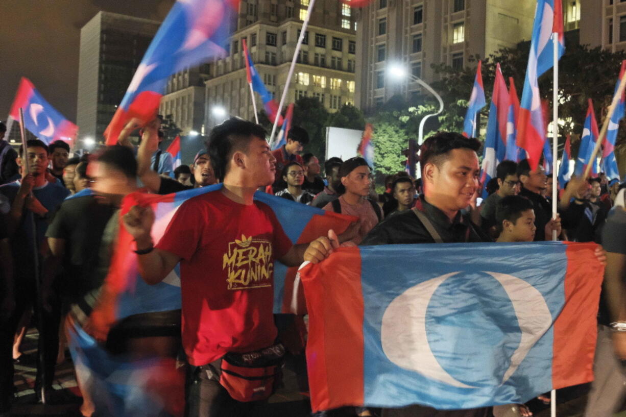 Opposition party supporters cheer and wave their party flags on the road leading to Prime Minister’s Office of Malaysia in Putrajaya, Malaysia, early Thursday, May 10, 2018. Unofficial results from Malaysia’s general election are showing a swing to the opposition. It remains unclear whether it is significant enough of a shift to end the ruling National Front’s 60-year hold on power.