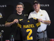 Former NFL quarterback and Heisman Trophy winner Johnny Manziel, left, holds a jersey with Hamilton Tiger-Cats head coach June Jones after announcing that he has signed a two-year contract to play for the CFL team at a press conference in Hamilton, Ontario, Saturday, May 19, 2018.