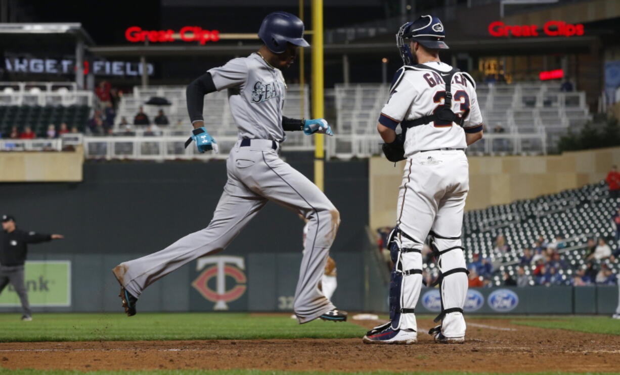 Seattle Mariners’ Dee Gordon, left, scores past Minnesota Twins catcher Mitch Garver on a sacrifice bunt by Jean Segura and a throwing error in the eighth inning of a makeup baseball game, Monday, May 14, 2018, in Minneapolis. The Mariners won 1-0.