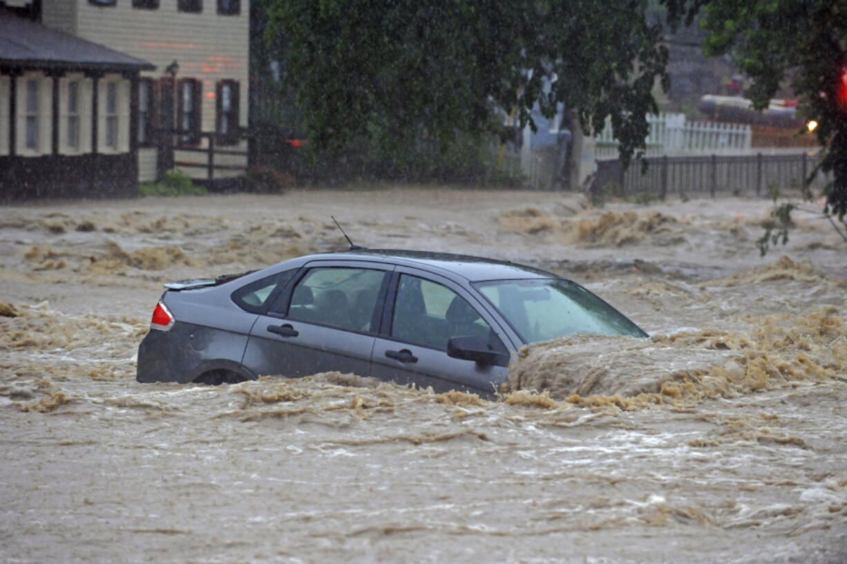 A parked car is flooded in a lot near Main Street and Ellicott Mills Road as a heavy storm caused flash floods in Ellicott City, Md., on Sunday. Roaring flash floods struck the Maryland city Sunday that had been wracked by similar devastation two years ago, its main street turned into a raging river that reached the first floor of some buildings and swept away parked cars, authorities and witnesses say. (Kenneth K.