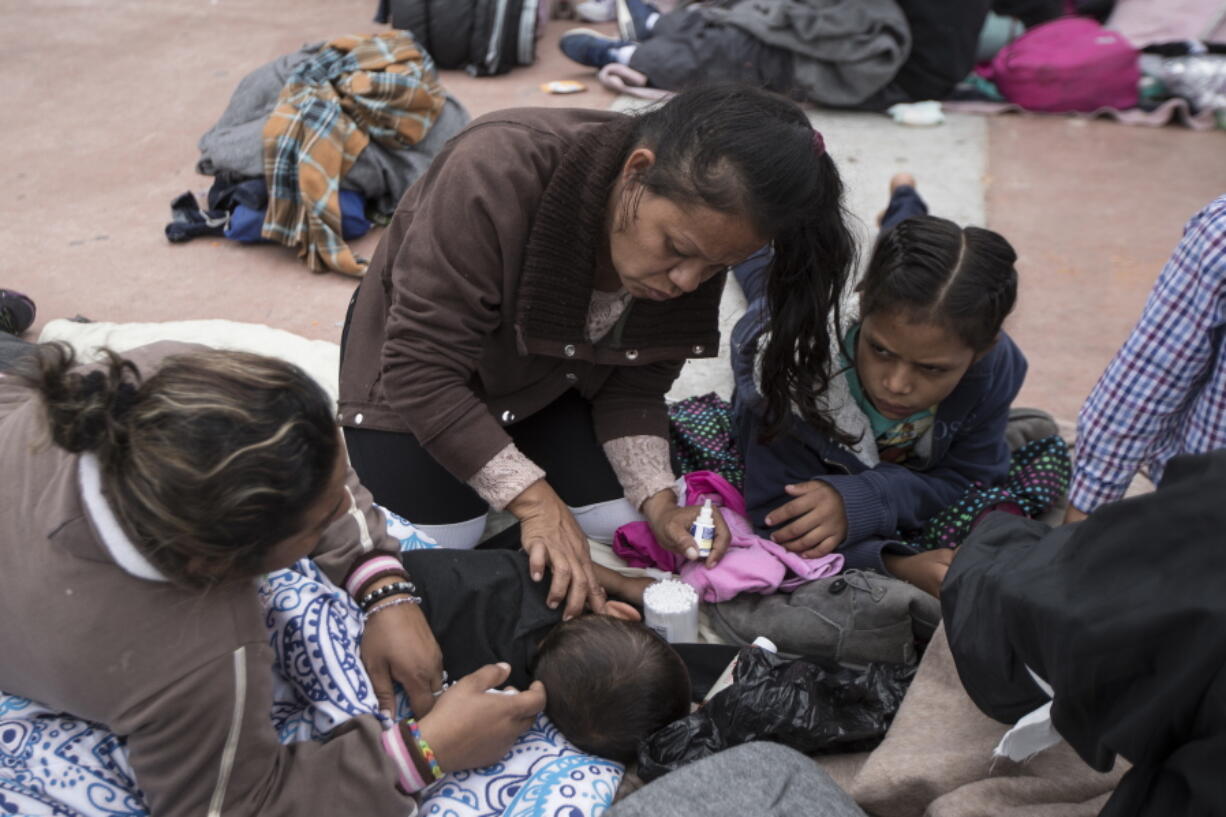 A two-year-old child from Honduras gets treatment for an ear infection after sleeping in the open in front of the El Chaparral port of entry, in Tijuana, Mexico, on Monday. About 200 people in a caravan of Central American asylum seekers waited on the Mexican border with San Diego for a second straight day on Monday to turn themselves in to U.S. border inspectors, who said the nation’s busiest crossing facility did not have enough space to accommodate them.