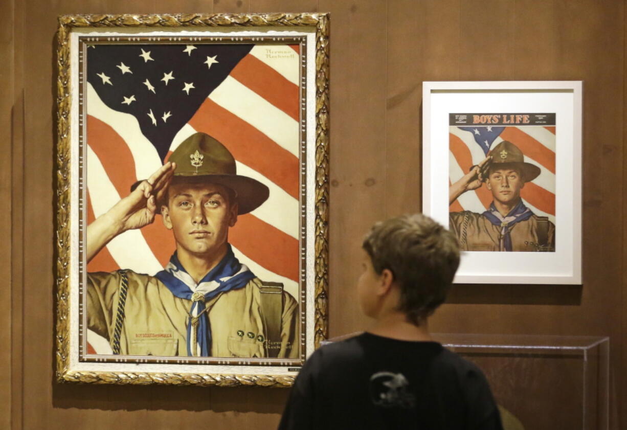 FILE - In this July 22, 2013, file photo, Andrew Garrison, 11, of Salt Lake City, looks over the Rockwell exhibition at the Mormon Church History Museum in Salt Lake City, Utah. Twenty-three original, Boy Scout-themed Norman Rockwell paintings were on display in Salt Lake City to celebrate the 100-year relationship between Scouting and the Mormon church. An announcement Tuesday night, May 8, 2018, by The Church of Jesus Christ of Latter-day Saints and Boy Scouts will mark an end to close relationship that lasted more than a century built on their shared values. The religion will move its remaining boys into its own scouting-type program.