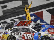 Kyle Busch celebrates after winning the NASCAR Cup Series auto race at Charlotte Motor Speedway in Charlotte, N.C., Sunday, May 27, 2018.