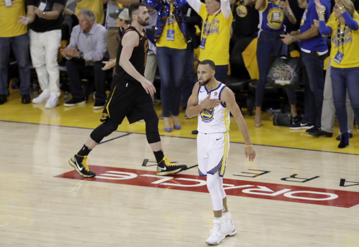 Golden State Warriors guard Stephen Curry (30) celebrates in front of Cleveland Cavaliers forward Kevin Love during overtime of Game 1 of basketball's NBA Finals in Oakland, Calif., Thursday, May 31, 2018.