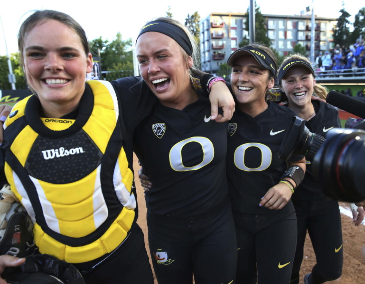 Oregon catcher Gwen Svelos, pitcher Miranda Elish, Lauren Lindvall and Jenna Lilley, from left, celebrate the team’s win over Kentucky in an NCAA softball tournament super regional, Saturday, May 26, 2018, in Eugene, Ore.