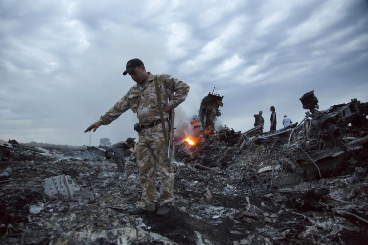 People walk amid the debris at the crash site of Malaysia Airlines Flight 17 on July 17, 2014, near the village of Grabovo, Ukraine.