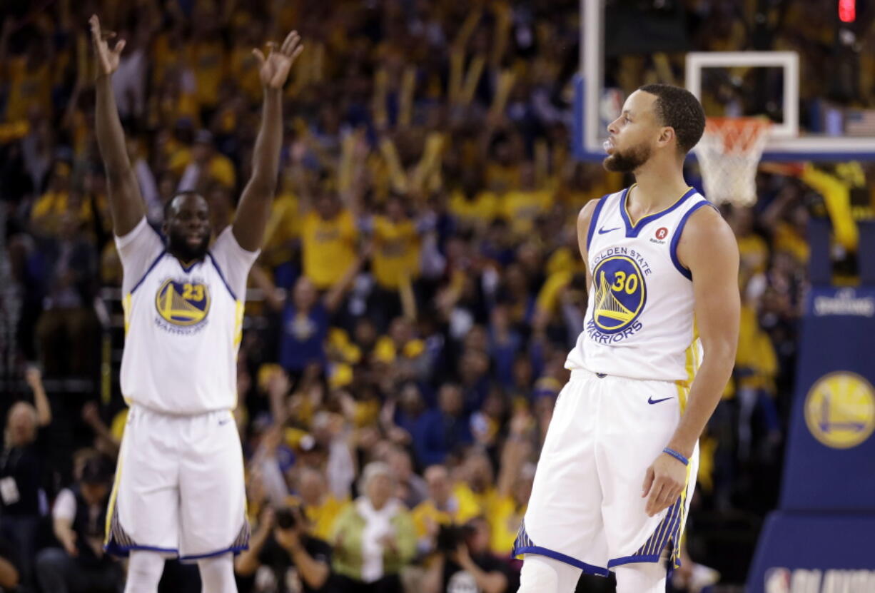 Golden State Warriors' Draymond Green, left, raises his arms in celebration after a 3-point basket by teammate Stephen Curry (30) during the second half in Game 5 of an NBA basketball second-round playoff series against the New Orleans Pelicans Tuesday, May 8, 2018, in Oakland, Calif.