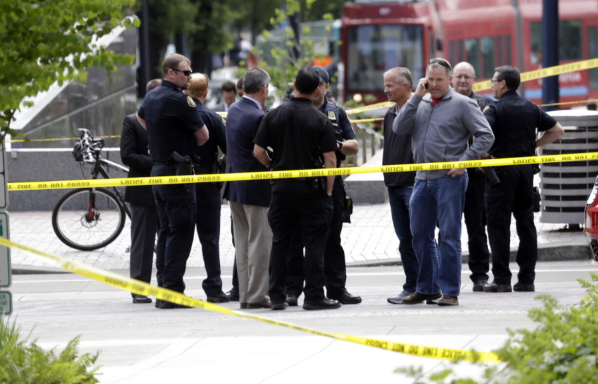 Officials gather at the scene where pedestrians were hit by a motorist in Portland, Ore., Friday, May 25, 2018. Police say three women have been injured in a hit-and-run crash near Portland State University.