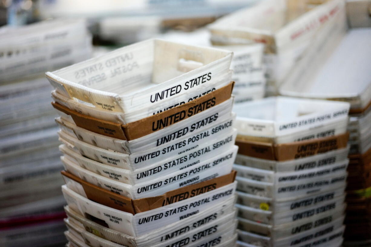 FILE- In this Dec. 14, 2017, file photo, boxes for sorted mail are stacked at the main post office in Omaha, Neb. The U.S. Postal Service is reporting another quarterly loss after an unrelenting decline in mail volume and costs of its health care and pension obligations overcame strong gains in package deliveries.