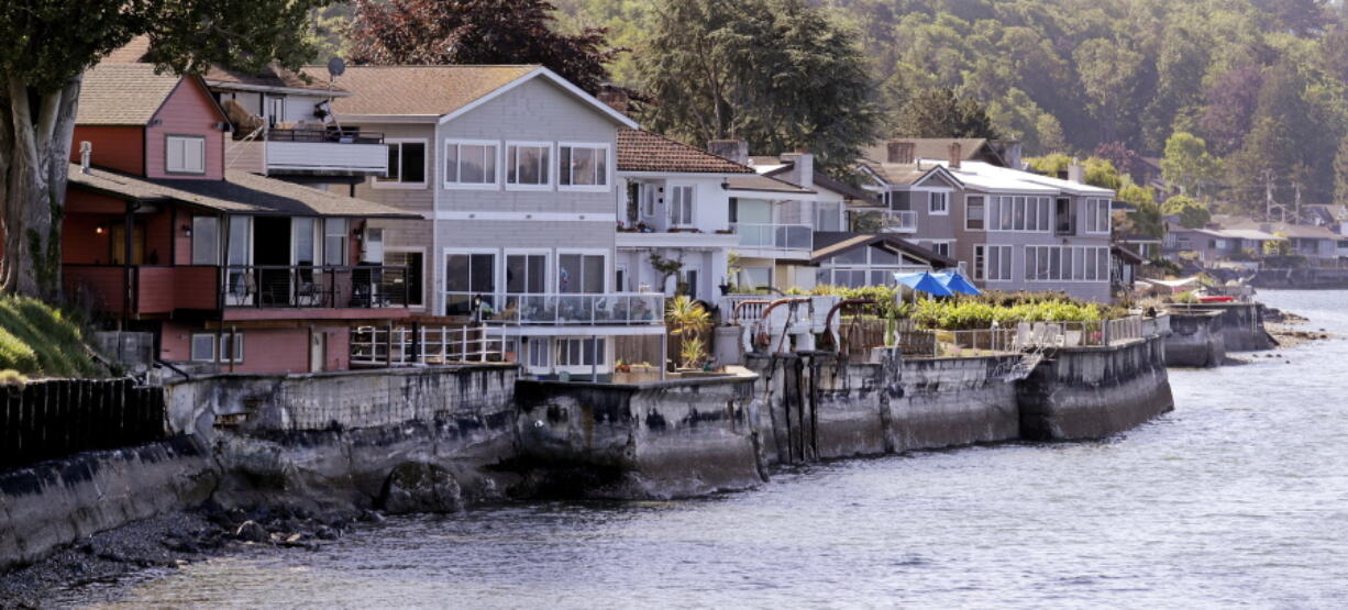 Home are fronted with concrete seawalls along the Puget Sound on Tuesday in Seattle. Three conservation groups have sued the U.S. Army Corps of Engineers over how it regulates seawalls, bulkheads, rip rap or other hard barriers in Puget Sound. Such concrete or rock structures prevent erosion and protect waterfront homes, but they alter beaches and disrupt habitat for juvenile salmon, forage fish and other species.