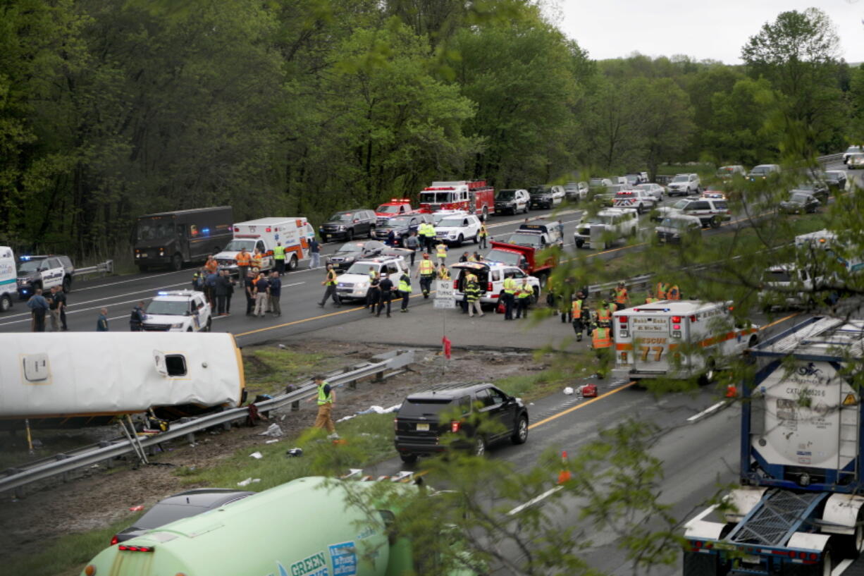 Emergency personnel work at the scene of a school bus and dump truck collision, injuring multiple people, on Interstate 80 in Mount Olive, N.J., Thursday, May 17, 2018.