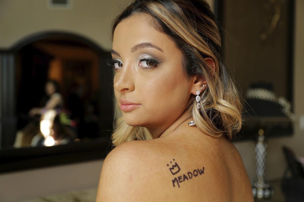 In this May 5, 2018 photo, Nicolette Miciotta displays the name of her best friend Meadow Pollack as a tribute as she and a group of friends get ready for the prom in Parkland, Fla. Meadow Pollack was one of the four Florida high school seniors slain in a mass shooting honored by their classmates celebrating their senior prom.